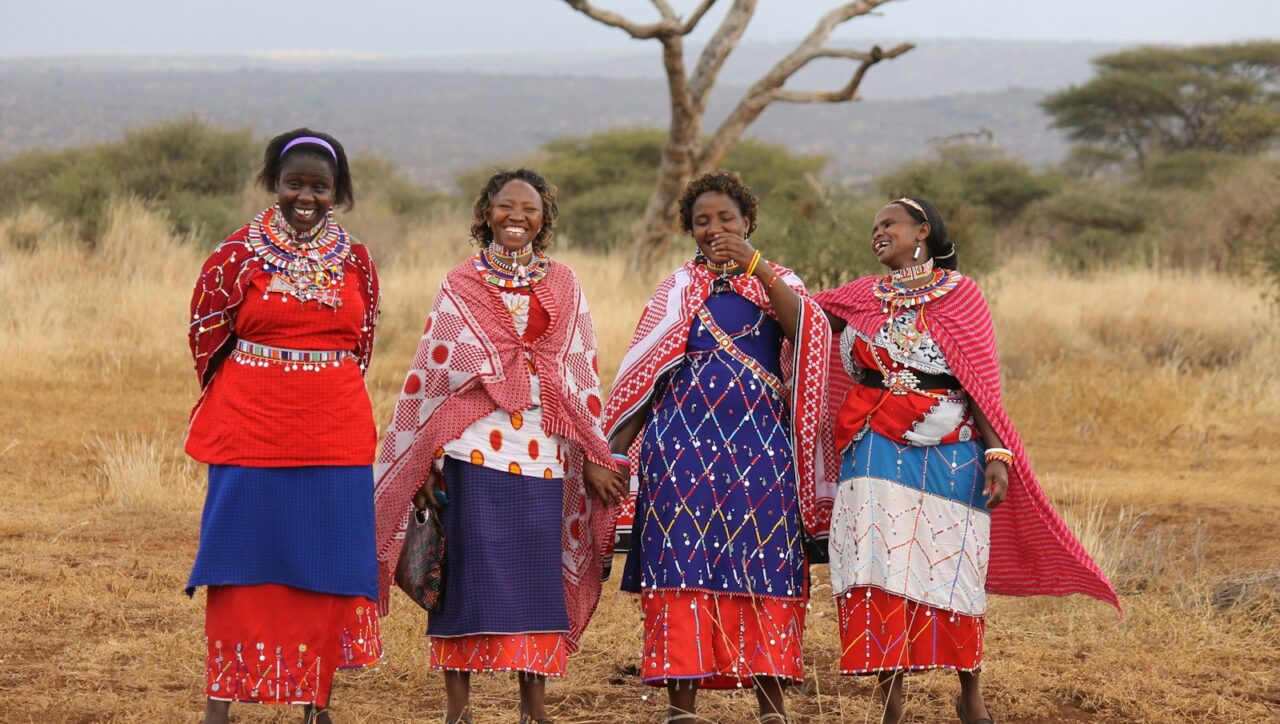 a group of women standing next to each other in a field